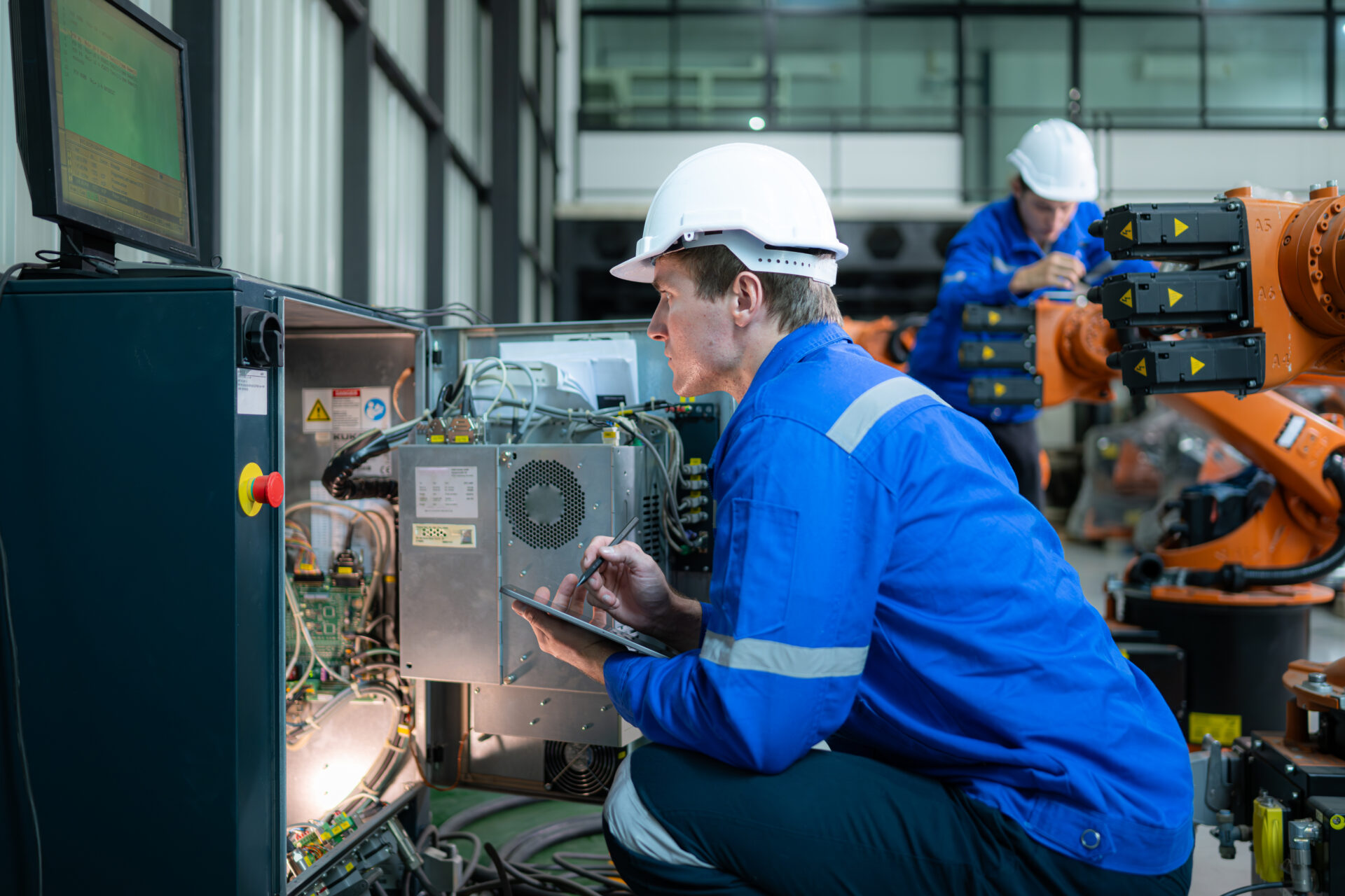 Technician working on the electrical control cabinet of robotic arm, Robotic arms industrial background